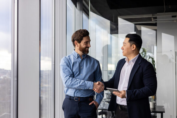 Professional businessmen shaking hands in office, colleagues and partners collaboration