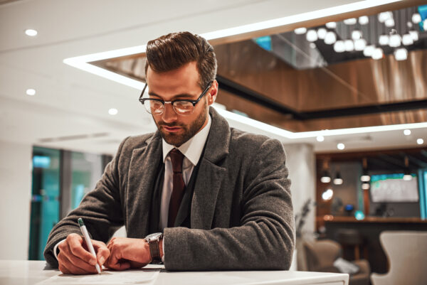 Man in Hotel check in at reception or front office, fulfills his profile