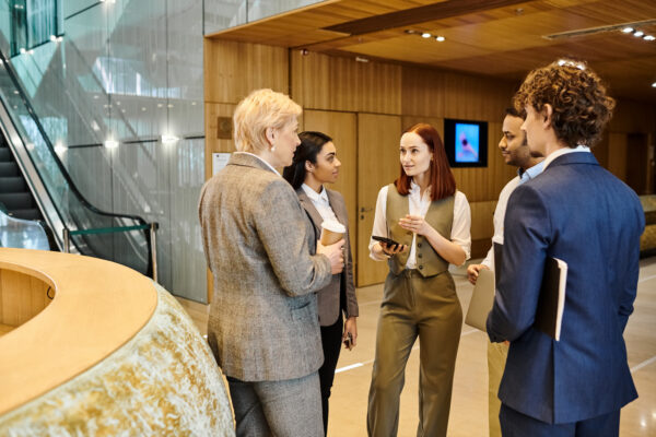 Multicultural business colleagues standing in circle, having a discussion.