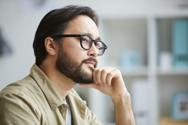 Creative Asian man deep in thoughts