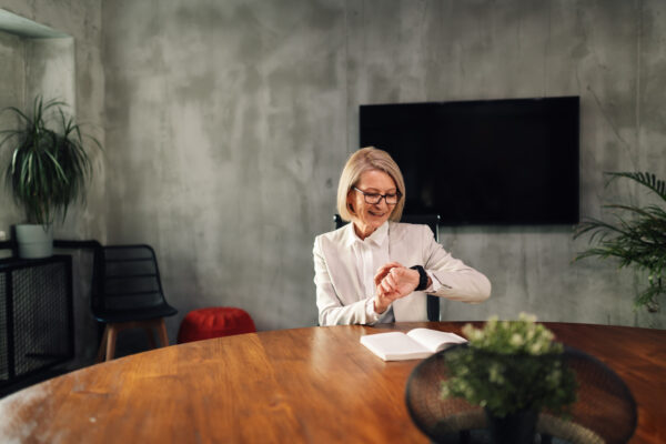 Portrait of a senior businesswoman looking what time it is in her office