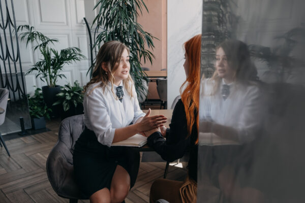 Empathy, friendly support, each other's support and sisterhood. Young woman comforting her friend sitting in cafe. Female Psychotherapist supporting her depressed patient.